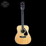A Yamaha dreadnought acoustic guitar with a natural wood finish and black pickguard, shown against a solid black background with a Tone Shop watermark in the top-left corner.