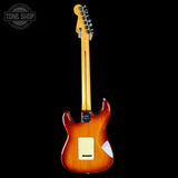 Electric guitar with a sunburst finish on a black background, featuring the Tone Shop logo.