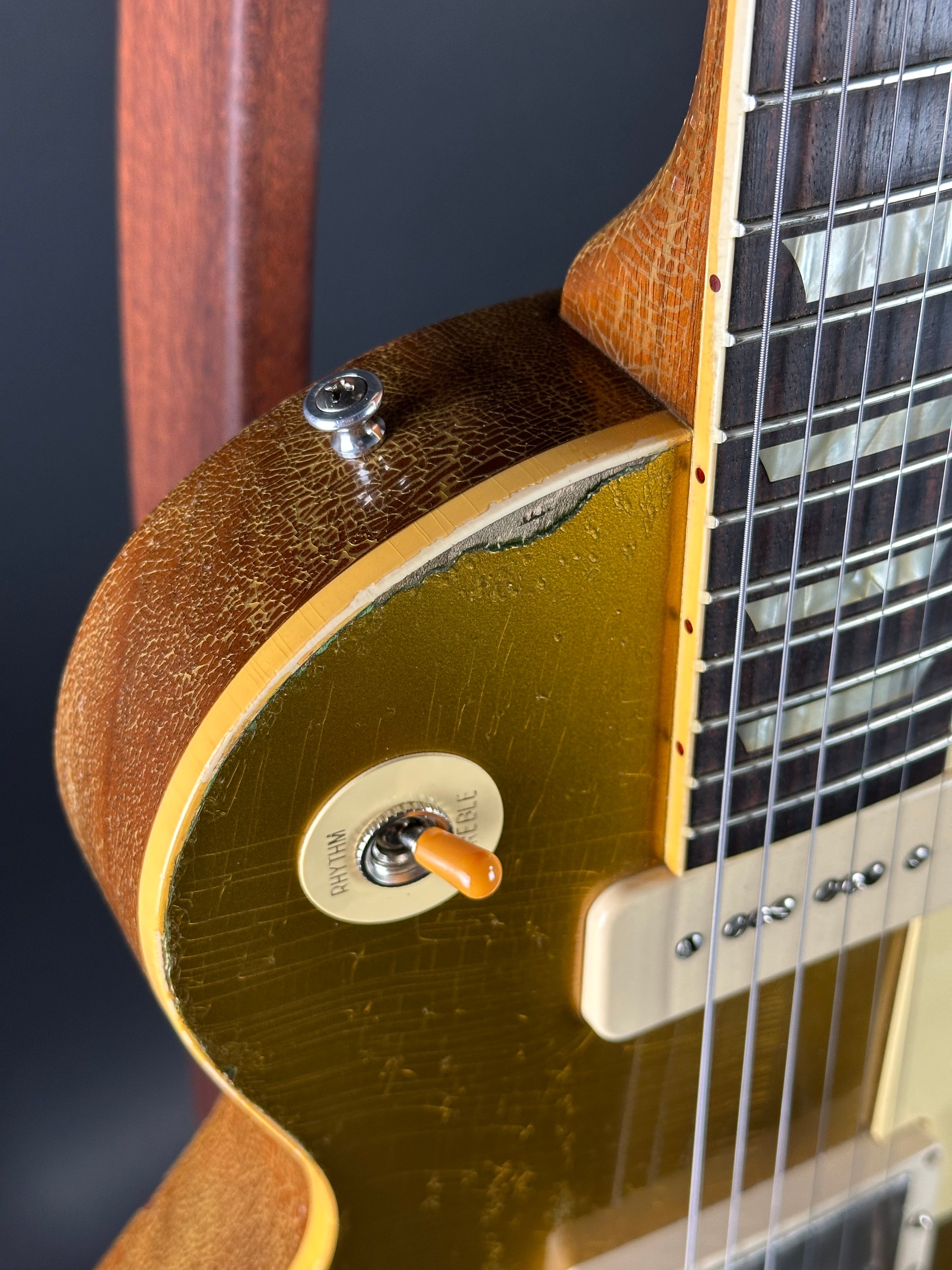 Close-up of a guitar's neck and headstock with a dark background
