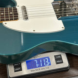 Blue electric guitar on a digital scale displaying weight