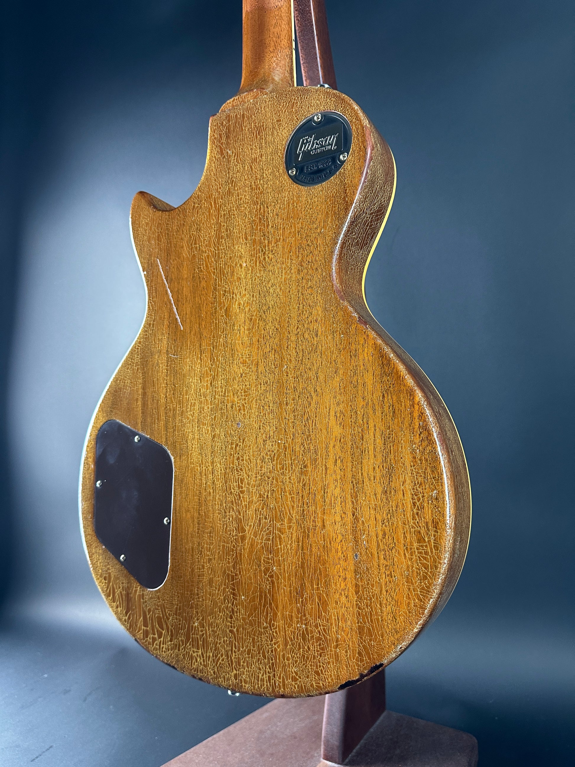 Close-up of a wooden guitar body with a dark blue background