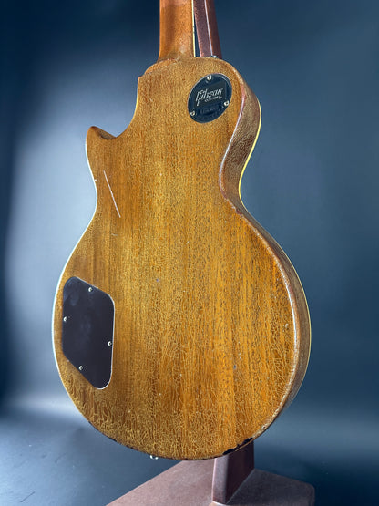Close-up of a wooden guitar body with a dark blue background