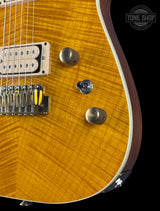 Close-up of a guitar with a sunburst finish, focusing on the neck and body.