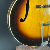 Close-up of a classic hollow-body electric guitar body, showing the sunburst finish that transitions from bright yellow-gold in the center to a dark black edge, with chrome hardware and a f-hole cutout.