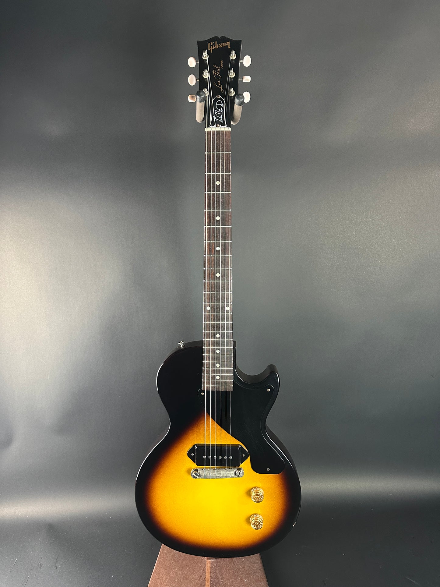 Electric guitar with a sunburst finish on a gray background