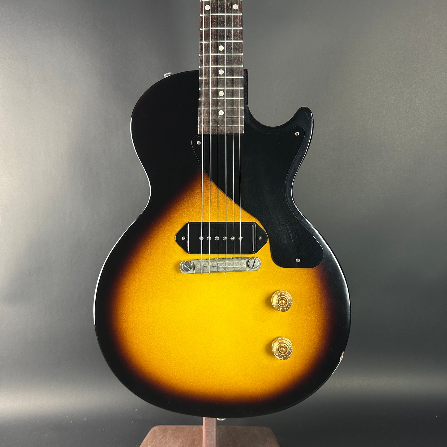 Electric guitar with sunburst finish on a gray background