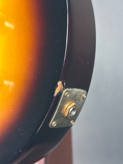 Close-up of a guitar's headstock with a visible brand emblem.