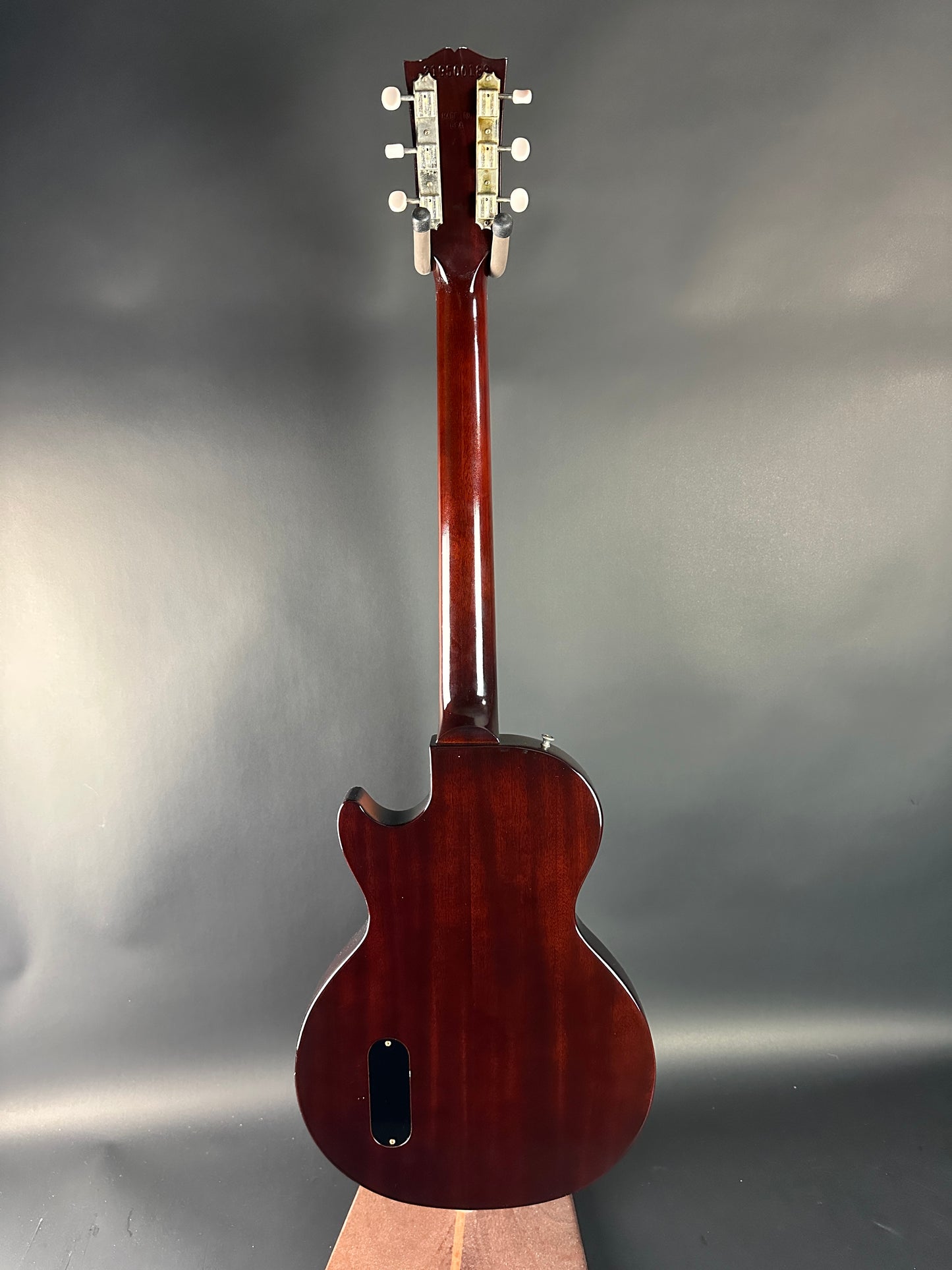 Top view of a brown guitar on a gray background