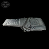 A dark gray padded guitar or bass gig bag with a front zippered pocket, shown against a solid black background. A Tone Shop logo watermark is visible in the top-left corner.