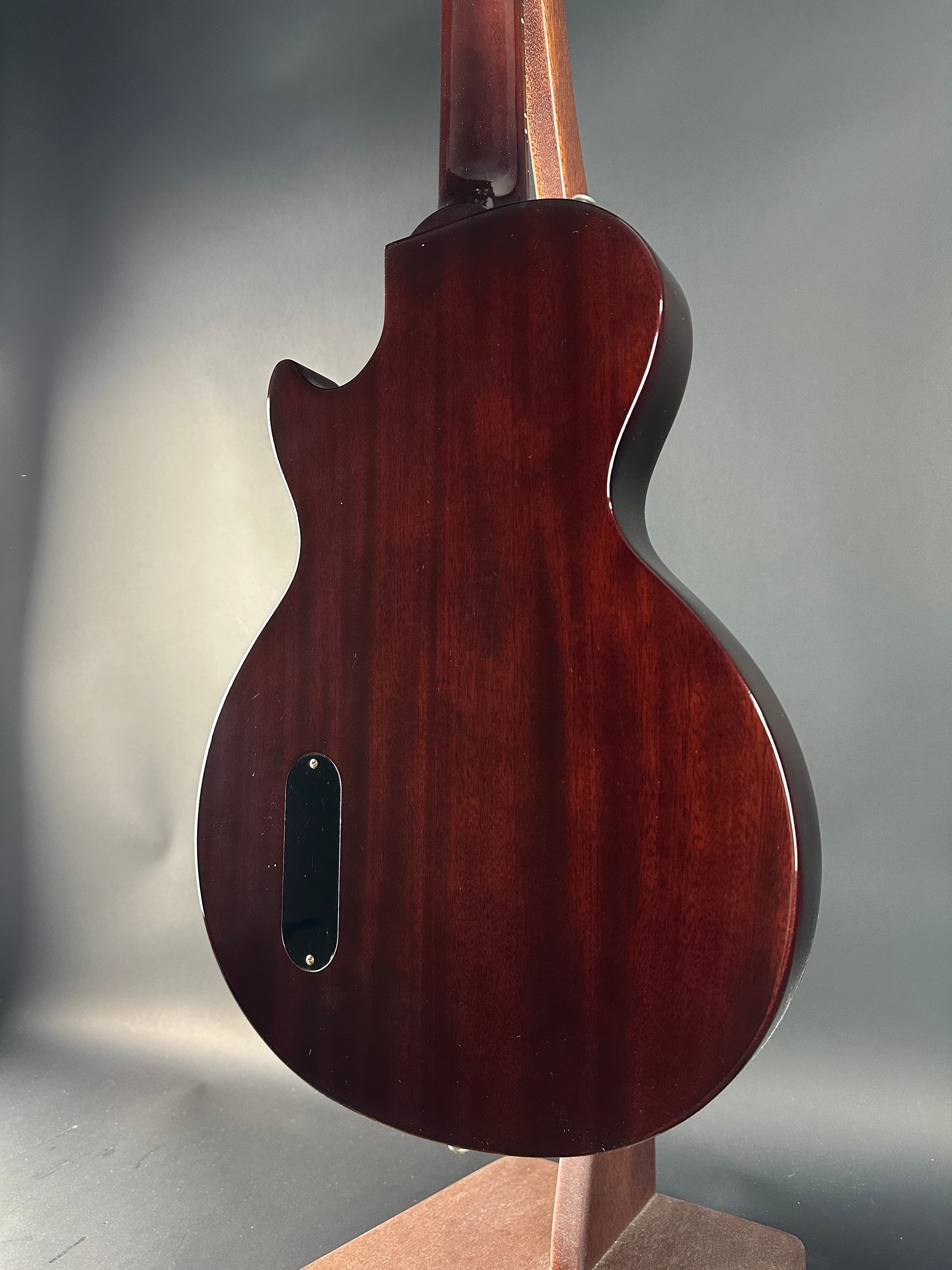 Close-up of a wooden guitar body on a gray background