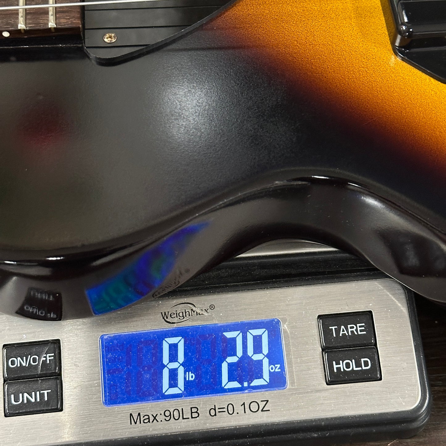 Guitar on a digital scale displaying weight