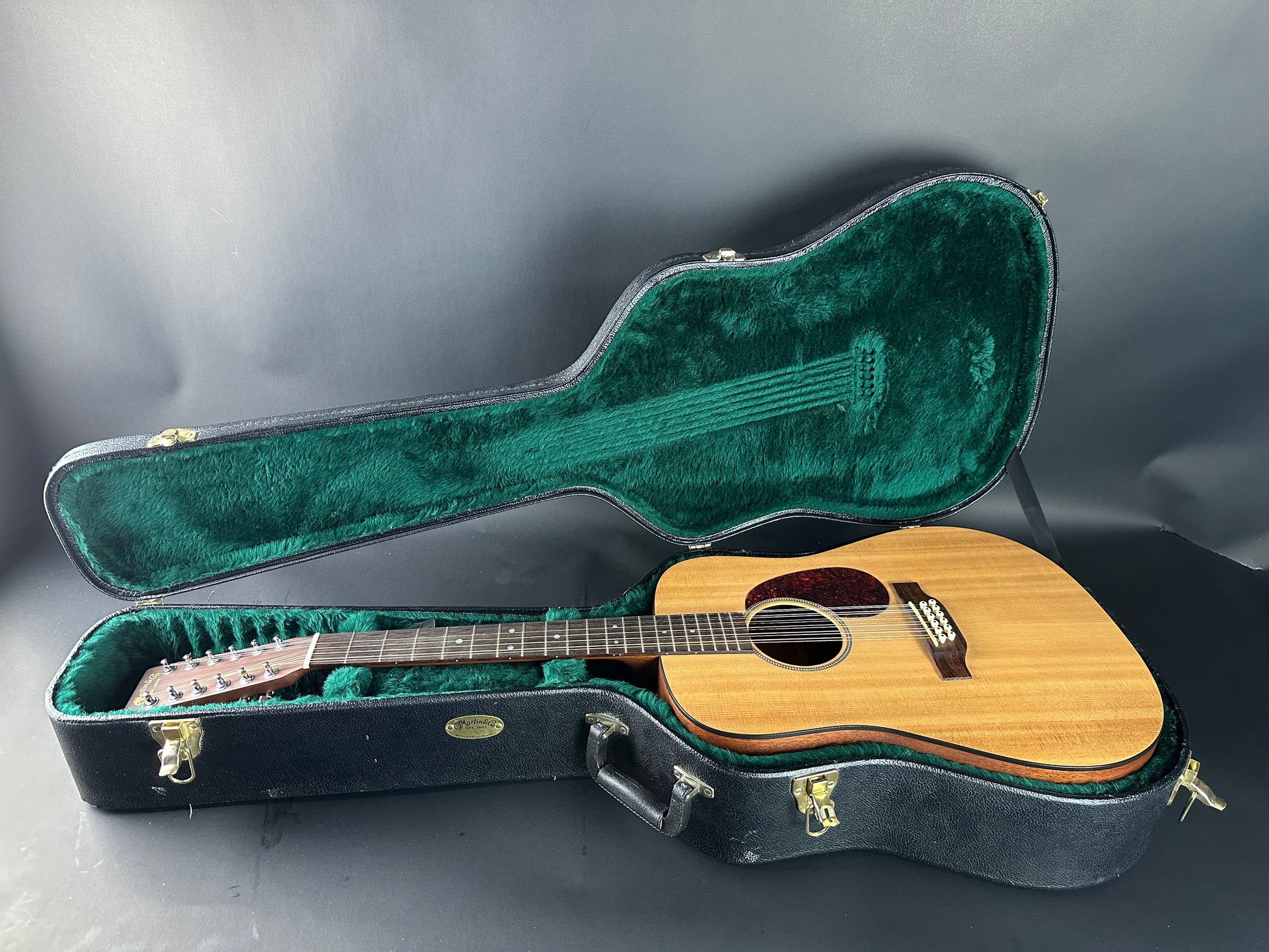 Acoustic guitar in an open case on a dark background