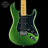 A green metallic electric guitar with a black pickguard and maple neck, shown against a solid black background with a Tone Shop watermark in the top left corner.