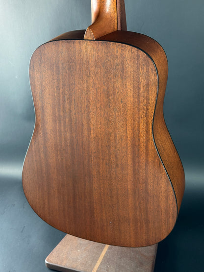 Close-up of a wooden acoustic guitar body on a gray background