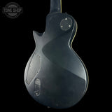 Black electric guitar body on a black background with 'Tone Shop' logo.