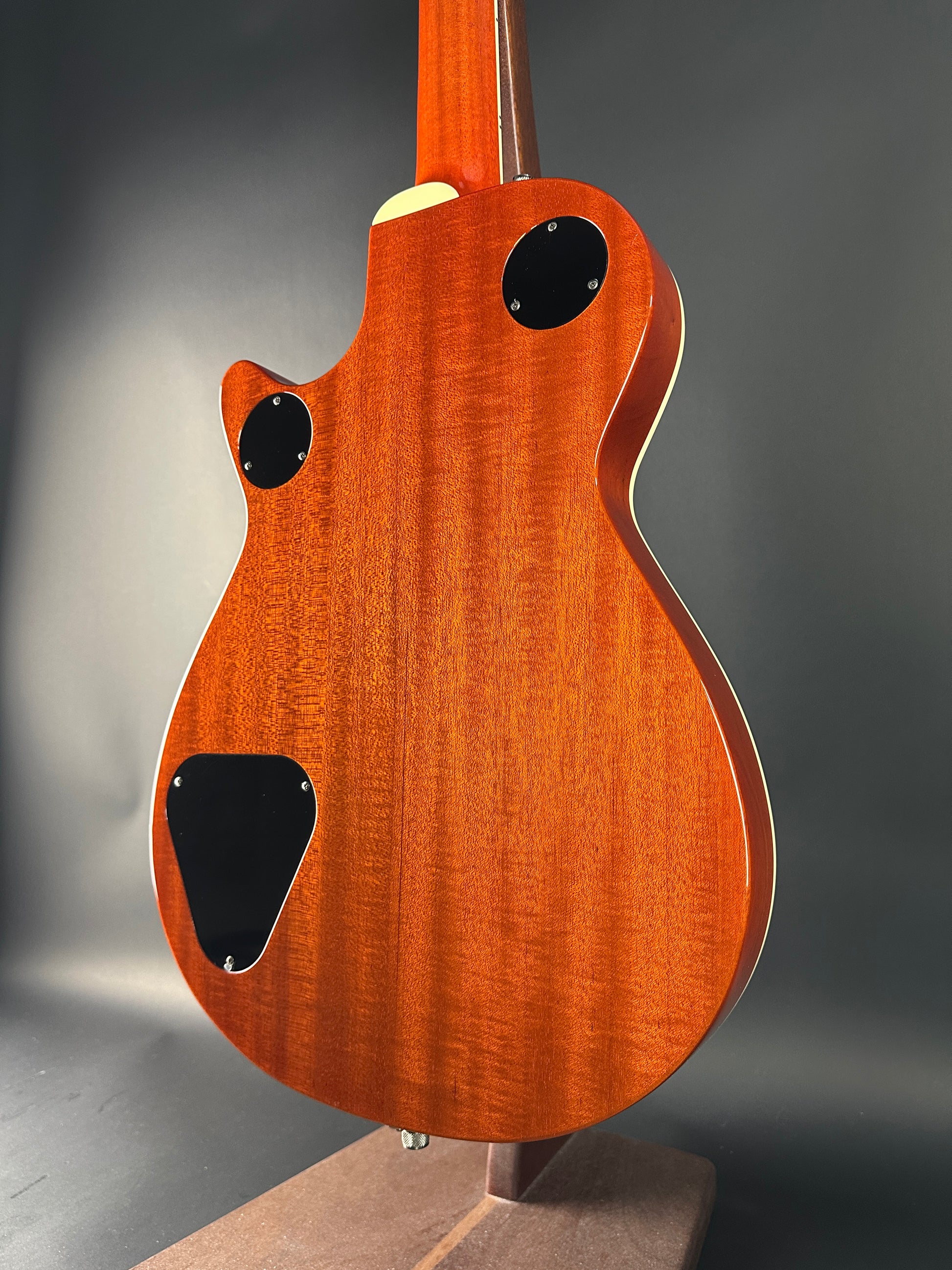 Close-up of a wooden electric guitar body on a dark background