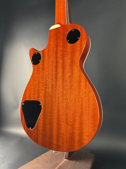 Close-up of a wooden electric guitar body on a dark background