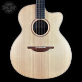Acoustic guitar with a visible brand logo on a black background