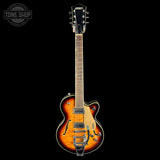 A Gretsch double-cutaway electric guitar with a sunburst finish, shown vertically against a solid black background. The guitar features a natural wood neck and headstock, chrome hardware, and a white Gretsch logo on the body.
