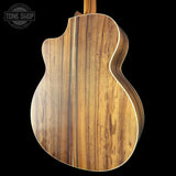 Close-up of a wooden acoustic guitar body with 'Tone Shop' logo in the corner.