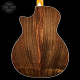 Close-up of a wooden acoustic guitar back with 'Tone Shop' logo.