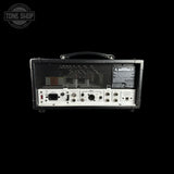 The rear view of a black guitar amplifier head with a handle on top, set against a solid black background. A Tone Shop watermark is visible in the upper left corner.