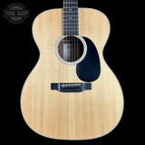 Acoustic guitar with a visible brand logo on a black background