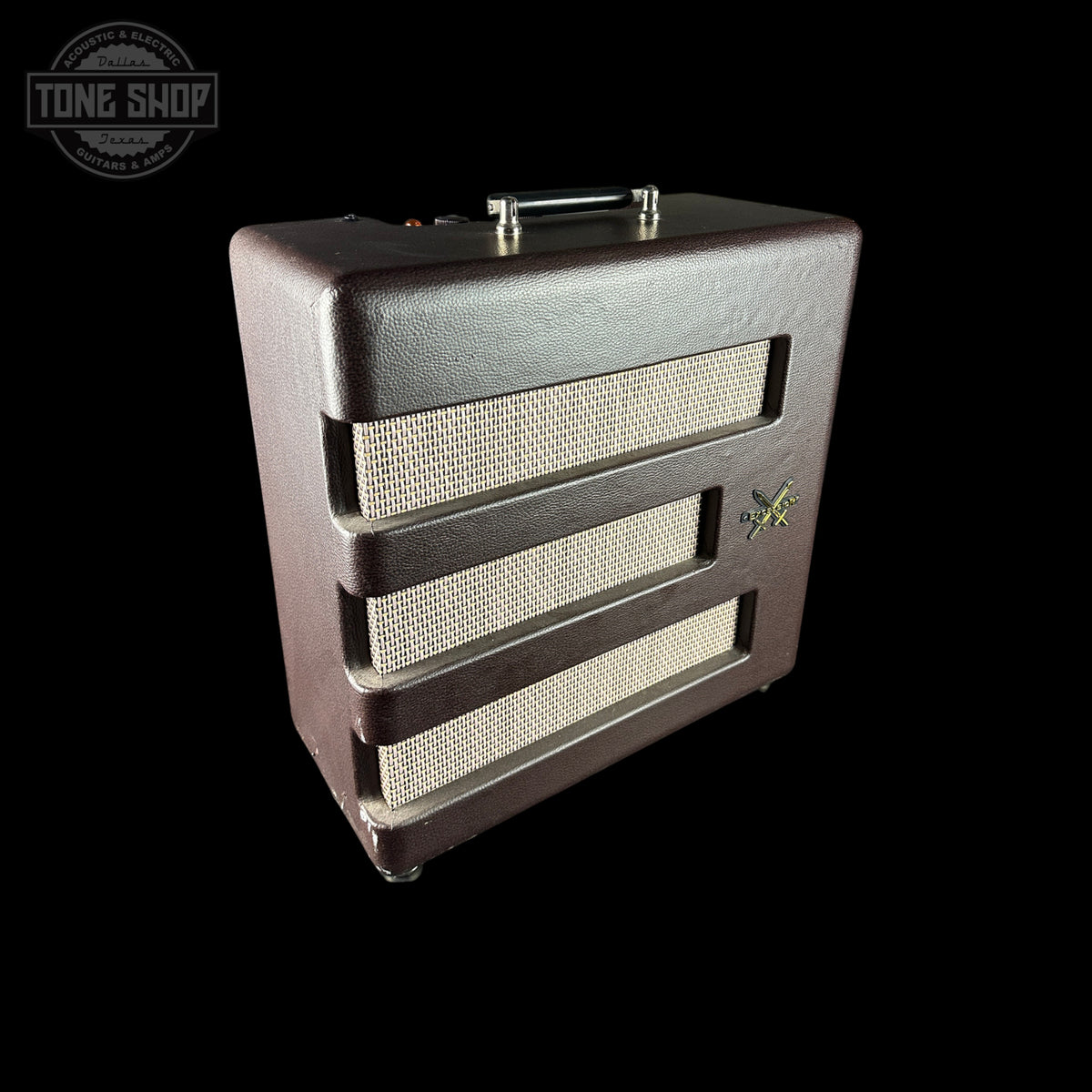 A vintage-style guitar amplifier speaker cabinet with a dark brown textured exterior, cream mesh grilles, and a top handle, shown against a solid black background. A 'TONE SHOP' watermark is visible in the top-left corner.