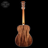 Back view of a wooden acoustic guitar with 'Tone Shop' logo in the corner.