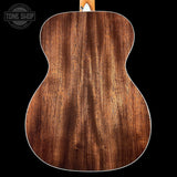 Close-up of a wooden acoustic guitar body with 'Tone Shop' logo.