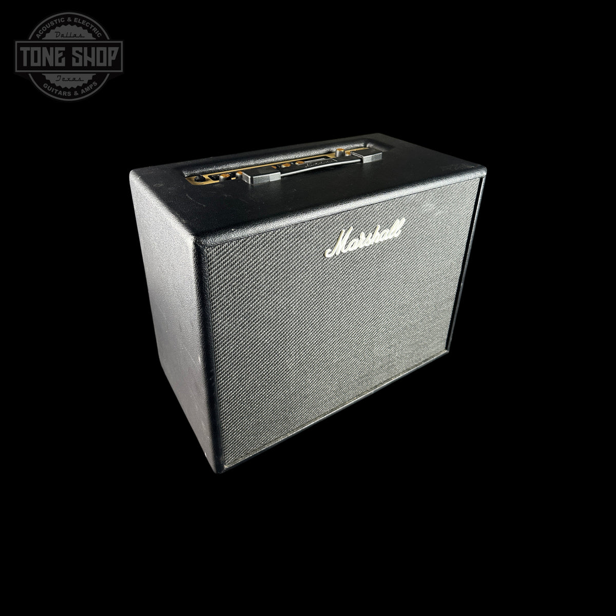 A Marshall guitar amplifier cabinet with a black textured grille and silver script logo, shown against a solid black background with a Tone Shop watermark in the top-left corner.