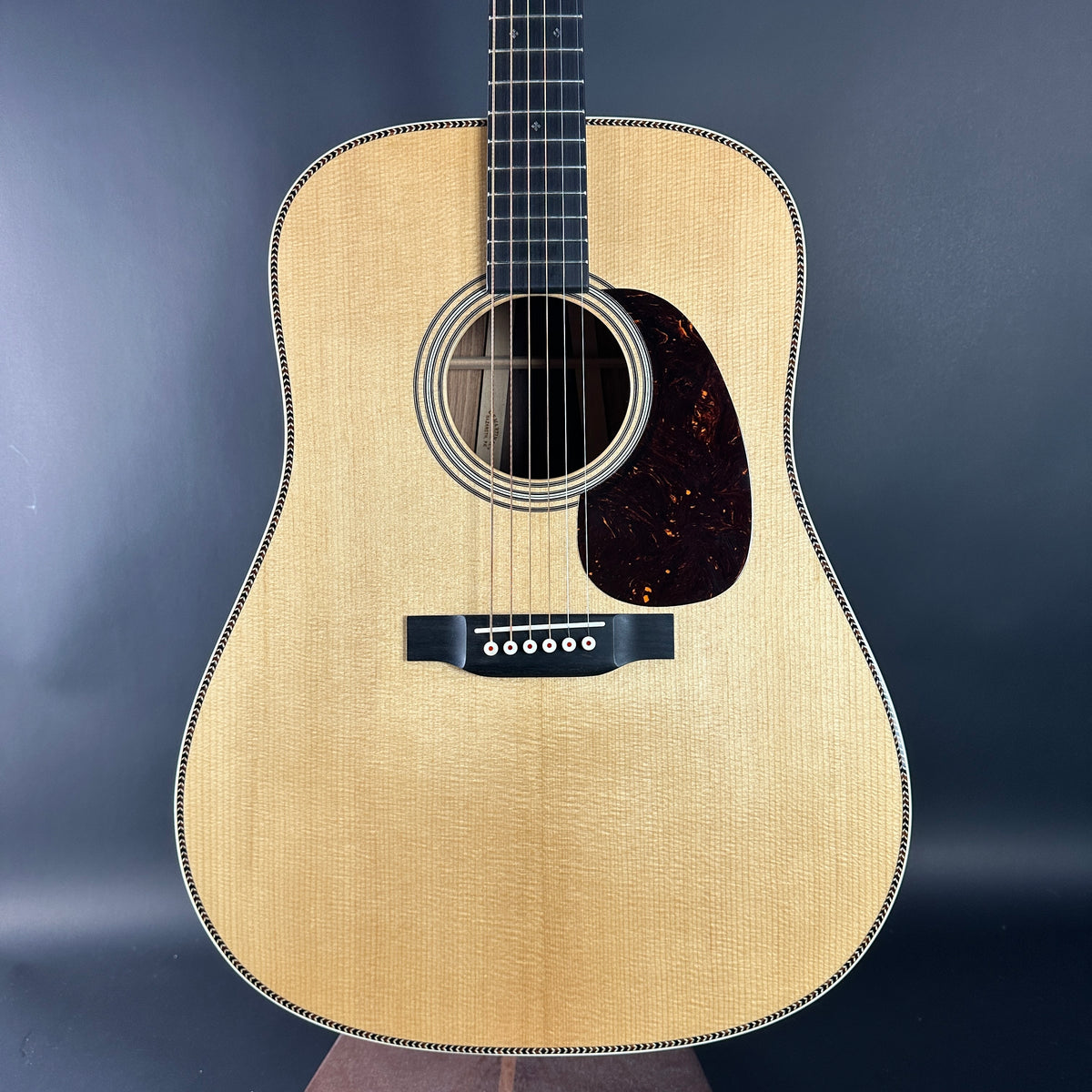 Acoustic guitar with a wooden finish on a dark background