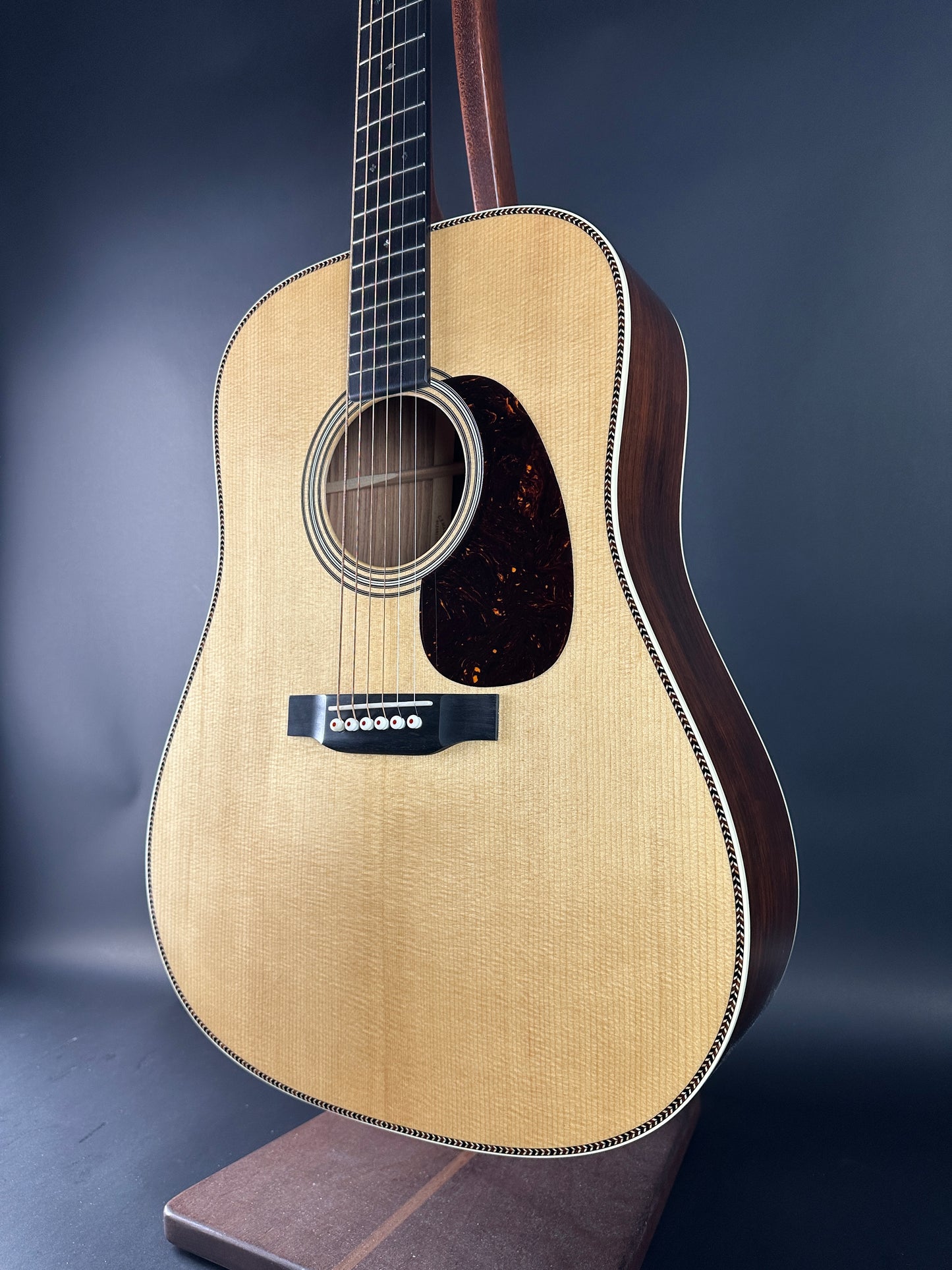Acoustic guitar with a dark brown finish on a blue background