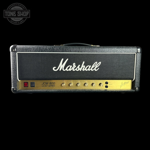 A Marshall JCM 800 LA-50S guitar amplifier head against a solid black background, featuring its signature black textured cabinet, white script logo, and gold control panel.