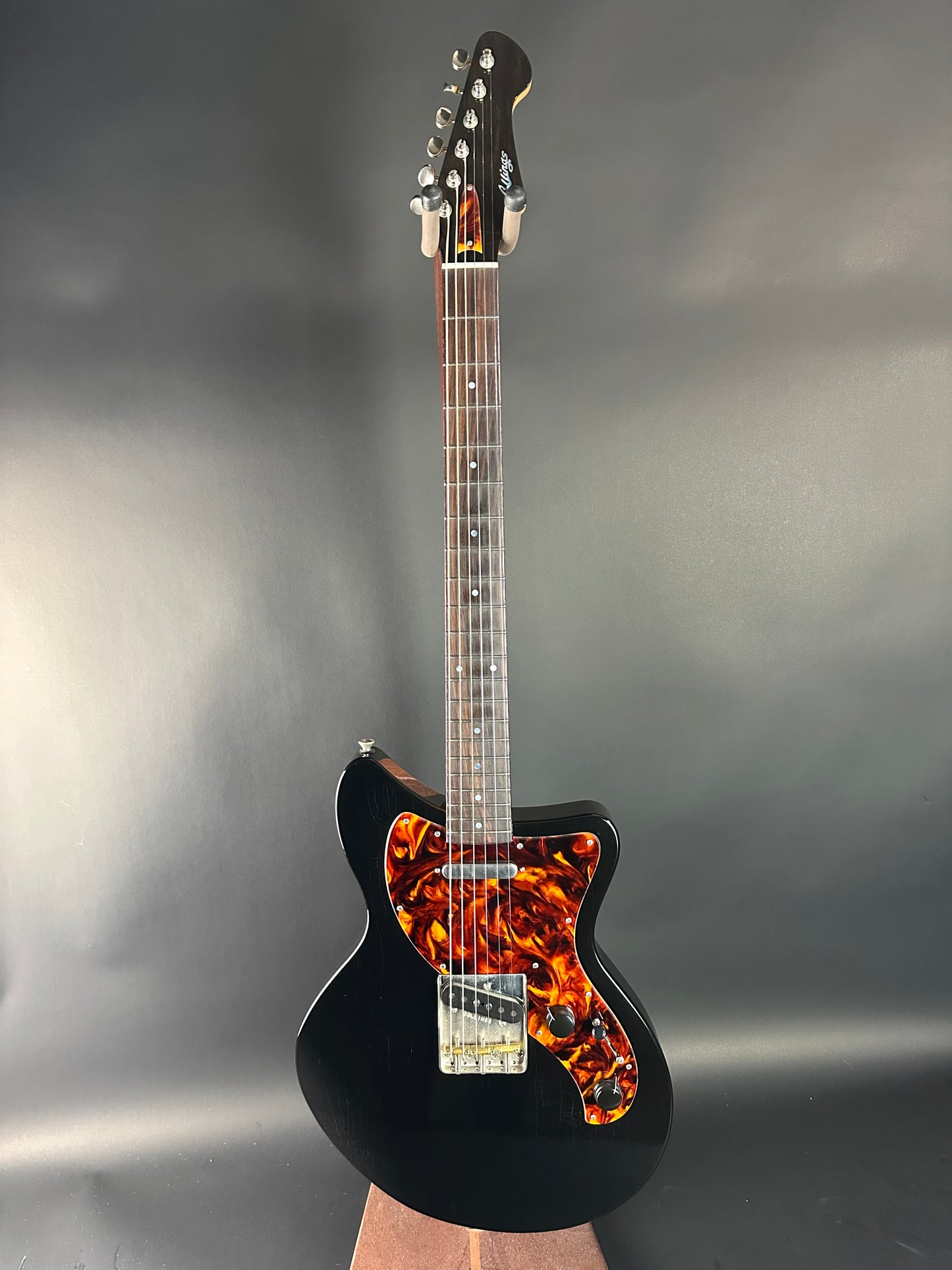 Black electric guitar with flame pattern on a gray background