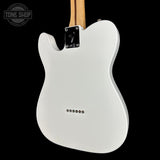 The back view of a white electric guitar against a solid black background, showing the glossy white body, silver hardware, and a portion of the natural wood neck. A 'TONE SHOP' watermark is visible in the top-left corner.