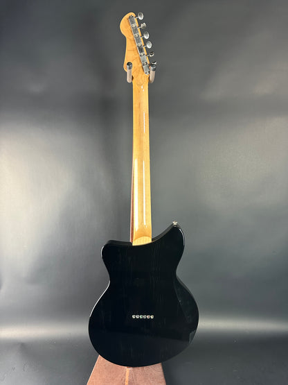 Black electric guitar on a gray background