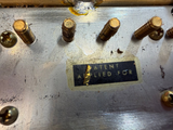 A close-up of a worn metal surface with several brass screws and a small black label that reads 'A LIEF LED FOR PATENT'.