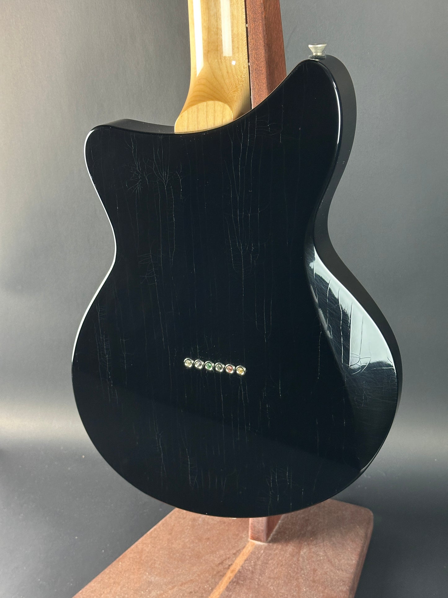 Black electric guitar body on a gray background