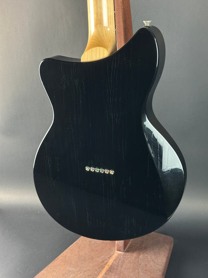 Black electric guitar body on a gray background