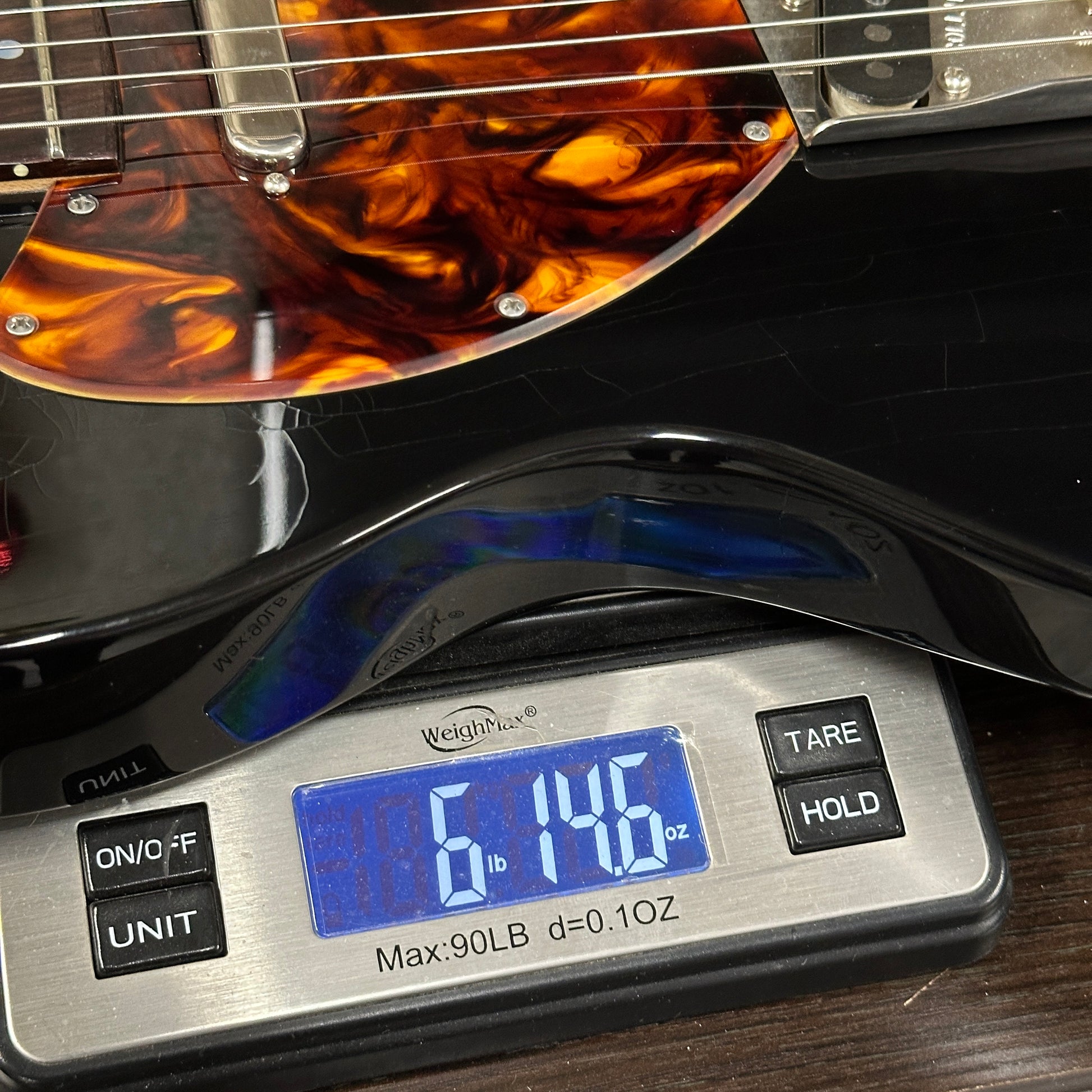 Guitar on a digital scale displaying weight