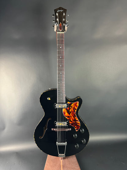 Black electric guitar with flame pattern on a gray background