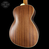 Back view of a wooden acoustic guitar with 'Tone Shop' logo.