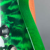 Close-up of a green electric guitar body with a glossy flamed maple finish, showing a small screw hole near the edge and part of a black control knob.