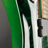 Close-up of an electric guitar body showing a glossy green finish, white binding, and part of the black bridge and strings.