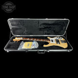 Electric bass guitar in a hard-shell case with 'Tone Shop' branding.
