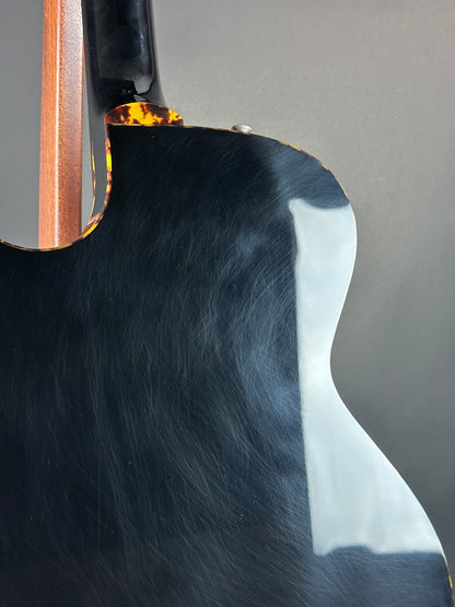 Close-up of a guitar's soundhole and neck on a gray background