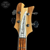 Close-up of a Rickenbacker bass guitar headstock on a black background with 'Tone Shop' logo.