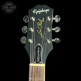Guitar headstock with 'Epiphone Les Paul' branding on a black background
