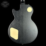 Guitar body with a black finish and gold pickguard, featuring the Tone Shop logo.